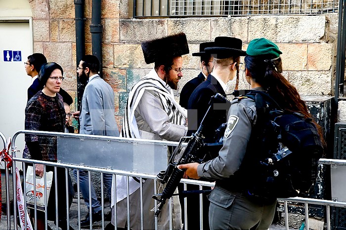 Orthodox Jews walking past a military checkpoint in East Jerusalem, Israel.