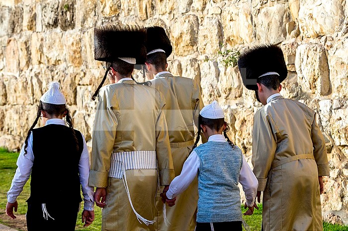 Orthodox jews walking along a wall of Jerusalem old city, Israel.