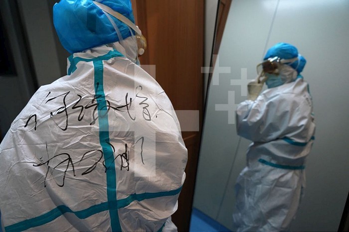 (200213) -- NANCHANG, Feb. 13, 2020 (Xinhua) -- Nurse He Shujuan wears a protective suit in front of a mirror at Xianghu Hospital of the First Affiliated Hospital of Nanchang University in Nanchang, east China’s Jiangxi Province, Feb. 6, 2020. Amid the novel coronavirus outbreak, numerous medical workers are engaged in the combat with the virus. At around 20:00 on Feb. 5, an ambulance sped in Xianghu Hospital, along with seriously-ill patients infected with novel coronavirus pneumonia from Fuzhou of Jiangxi Province. Doctors and nurses immediately put on protective equipment to perform treatment. Three hours later, another batch of medical workers arrived to take the shift till early next morning. Around 2:00 a.m. on Feb. 6, the patients were out of danger and steady. 