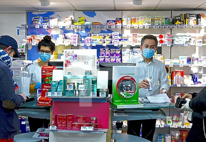Pharmacists and clients with protective masks and gloves in a pharmacy at the time of the coronavirus pandemic that spreads COVID-19.