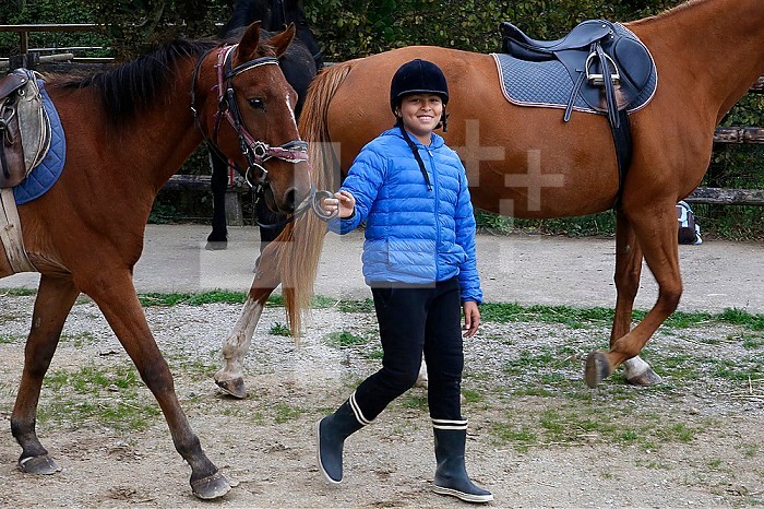 Teenager pulling a poney in Beaumesnil, France.