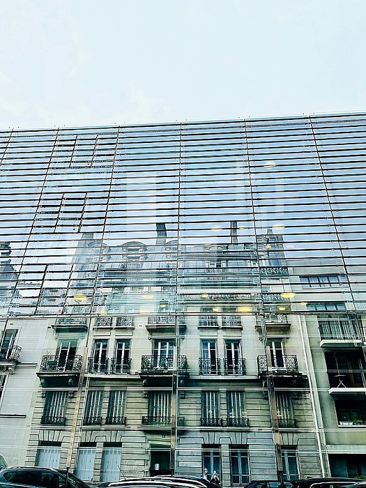 Old building reflected on a mirror building to illustrate the necessary transformation of old buildings, thermal strainers, to comply with new insulation standards. Paris, Ile-de-France, France.