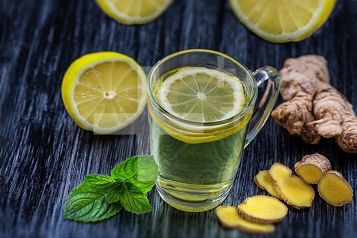 Herbal tea with ginger and lemon in a glass cup.