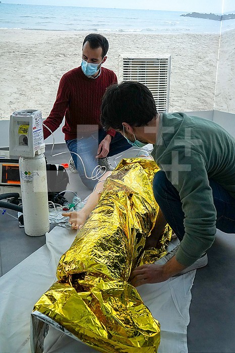Emergency medicine students attends a circumstantial emergency simulation course led by two emergency physicians. Simulation of a drowning case at the beach. Realistic images and sound are projected all around the room to immerse students in total immersion. A young girl came up to the water´s edge in cardiac arrest.