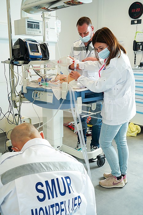 Newborn dummy emergency care training with breathing aid. Training at the CESU, Center for teaching emergency care at the Faculty of Medicine of Montpellier. Different healthcare professionals train in real emergency situations on a SimNewB newborn dummy. The newborn is cared for by an emergency doctor assisted by doctors from the SMUR. The newborn should be intubated to facilitate artificial respiration.