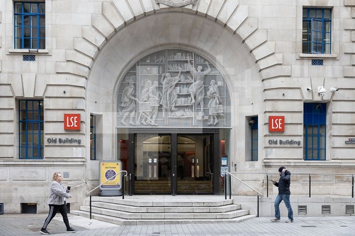 London, England, UK, 8 February 2022 - Students walk by the entrance of the Old Building (1923) on the campus of the London School of Economics and Political Science (LSE) in the Holborn area.. London School of Economics