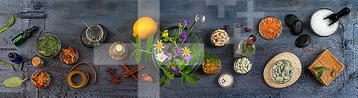 Panoramic of various alternative medicines viewed from above on a rustic gray background.