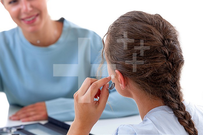 Woman in front of a hearing care professional testing a hearing aid.