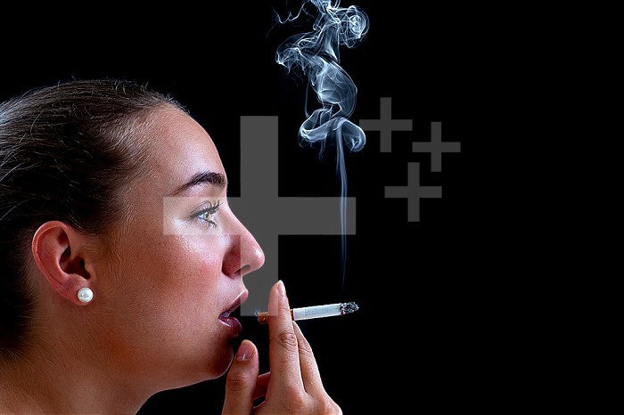 Close-up of a woman smoking a cigarette against a black background, creating billowing smoke.