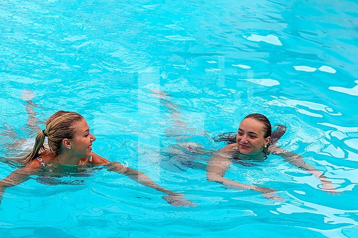 2 young women swimming breaststroke top view