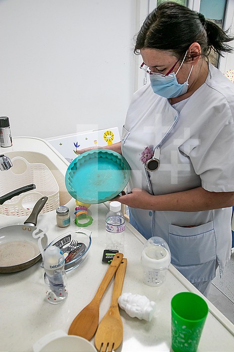 Educational room in which the nurse explains to the parents which are the good and bad products to use for their baby. Here a pie mold to avoid because food is encrusted in the dish.