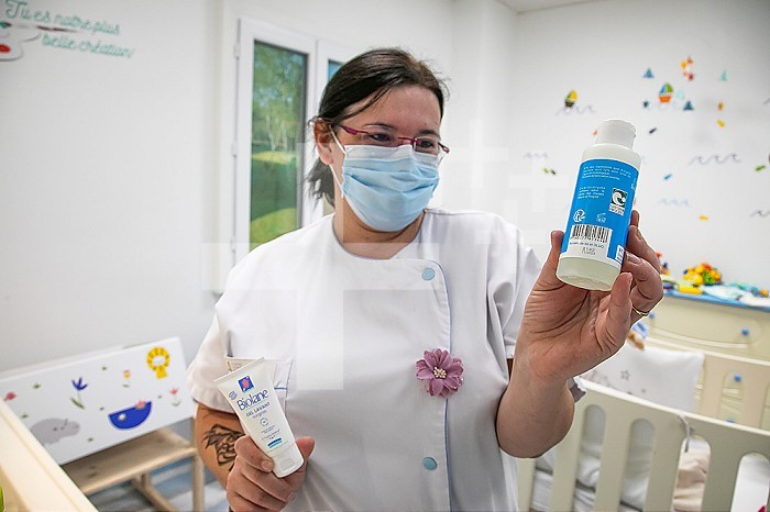 Educational room in which the nurse explains to the parents which are the good and bad products to use for their baby. Here the nurse compares two cleansing gels. The blue one is healthier because contains much less components.