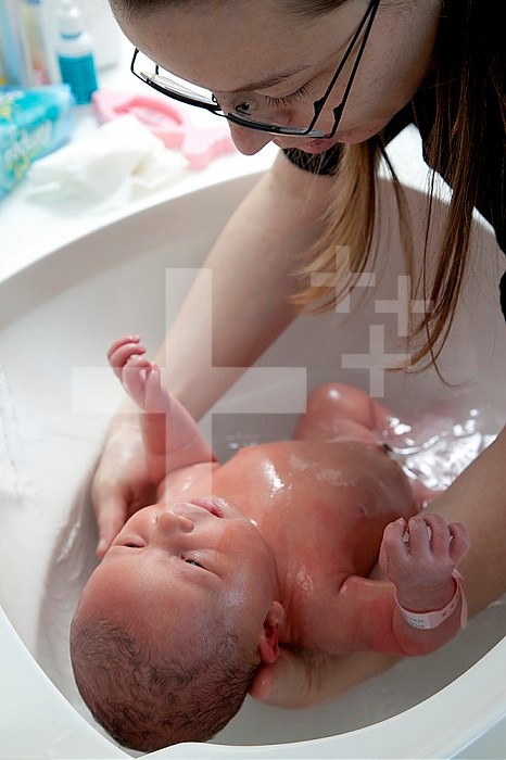 After checking the water temperature, the newborn bathes. Infant toilet.