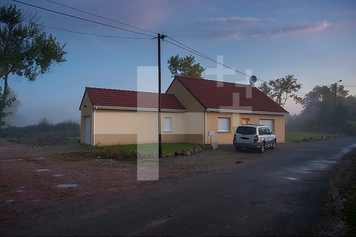 ADMR 62 - Home Help in Rural Areas, Pas de Calais. Muriel, Auxiliary of Social Life (AVS) works at the home of Mr. T. who is severely handicapped by Multiple Sclerosis. Muriel must help her with all the daily tasks. Rural village house at daybreak.