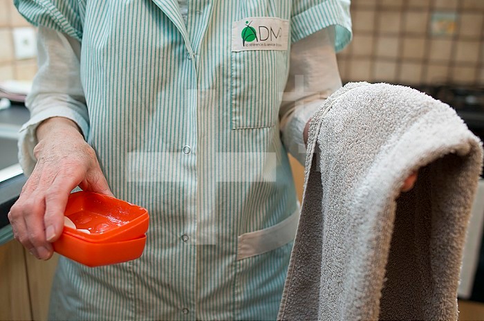 ADMR 62 - Home Help in Rural Areas, Pas de Calais. Muriel, Auxiliary of Social Life (AVS) works at the home of Mr. T. who is severely handicapped by Multiple Sclerosis. Muriel must help her with all the daily tasks. Carer wearing soap and towel before washing.