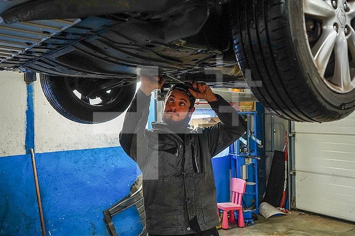 Business immersion of five workers from the mechanical workshop of an ESAT. Under the responsibility of auto mechanic professionals, workers with disabilities are trained in the mechanics profession and work independently in the workshop. Preparing a car for oil change and maintenance.