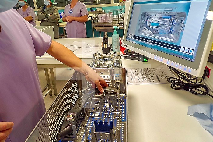 Operator filling an orthopedic surgery instrument with the image on a computer, with a view to its sterilization.