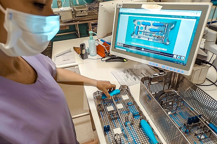 Operator filling an orthopedic surgery instrument with the image on a computer, with a view to its sterilization.